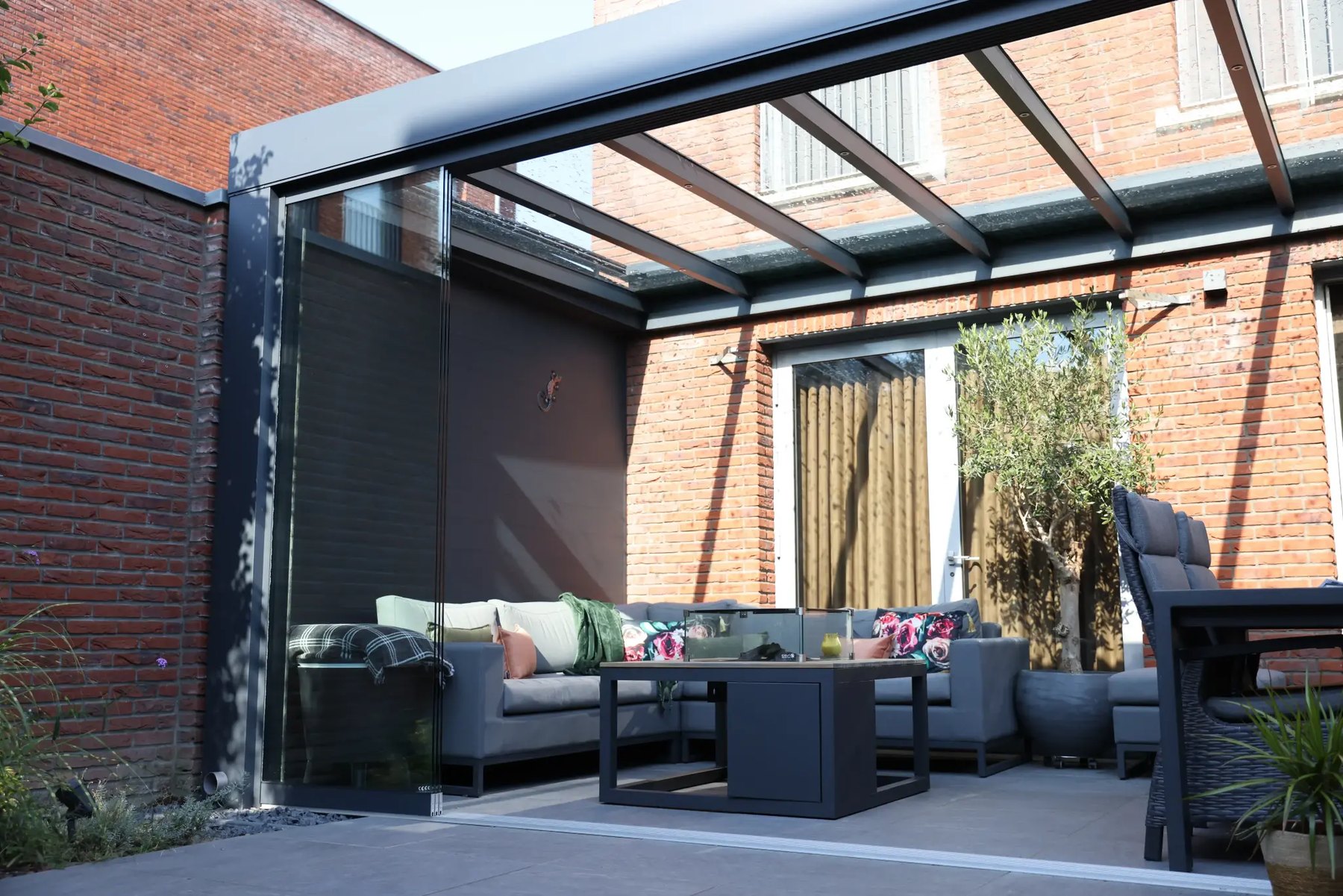 Veranda met glazen schuifwanden en loungeset
